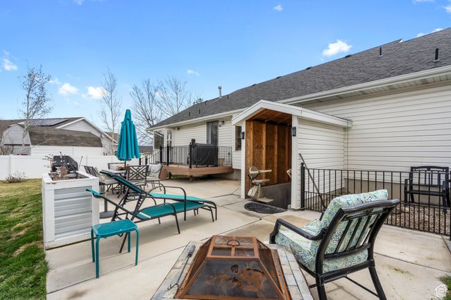 View of patio / terrace with an outdoor fire pit and outdoor dining area and COVERED Walkout with E chair if NEEDED | Image 32