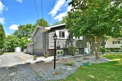 View of front of home featuring a garage, a front yard, and a storage shed | Image 2