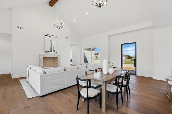 Dining area featuring beam ceiling, wood finished floors, baseboards, visible vents, and an inviting chandelier | Image 6