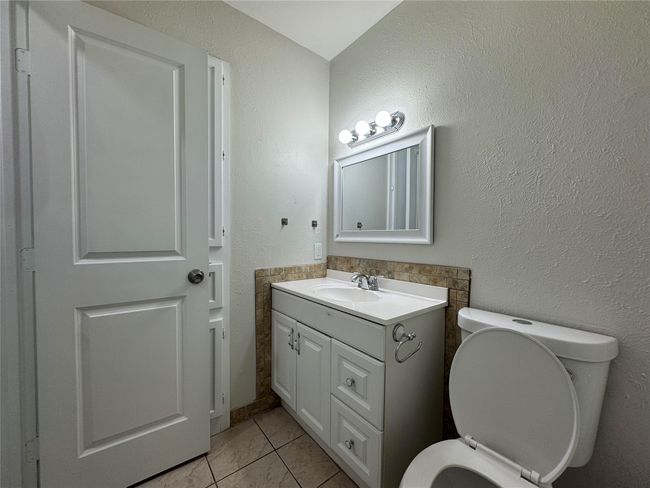Bathroom featuring a textured wall, vanity, and toilet | Image 18