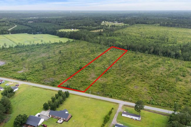 Aerial view of property and surrounding area featuring property parcel outlined and a heavily wooded area | Image 11
