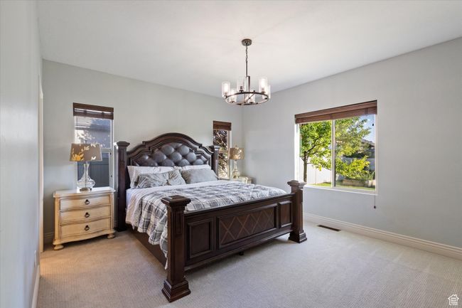 Bedroom featuring multiple windows, a chandelier, and light colored carpet | Image 8