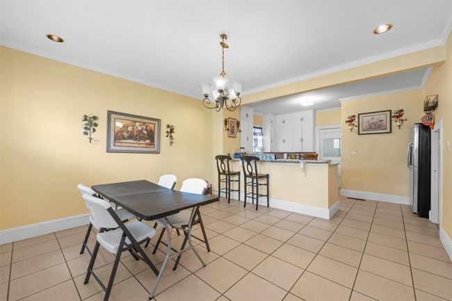 Dining room featuring crown molding, a chandelier, light tile patterned flooring, and recessed lighting | Image 8