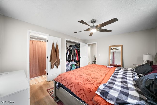 Bedroom with ceiling fan, light wood-style floors, connected bathroom, and a closet | Image 12
