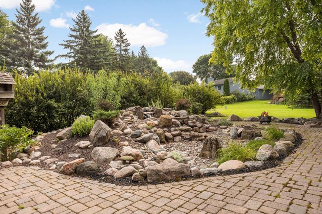 The backyard landscaping includes a relaxing water feature. | Image 32