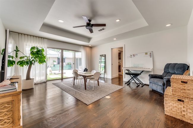 Dining room with a tray ceiling, ceiling fan, wood finished floors, and recessed lighting | Image 4