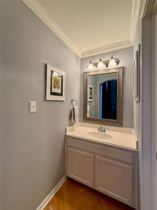 Bathroom with crown molding, a textured ceiling, baseboards, and vanity | Image 27