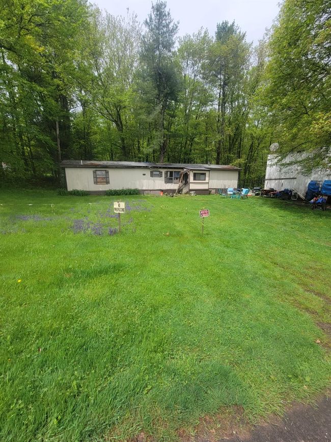 View of grassy yard featuring view of wooded area | Image 18
