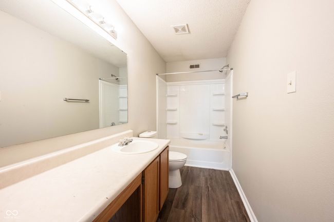full bathroom featuring wood finished floors, visible vents, toilet, vanity, and baseboards | Image 34