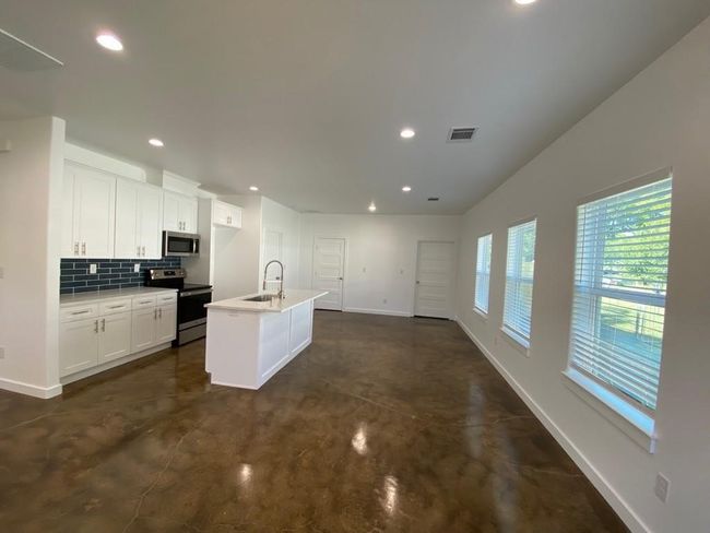 Kitchen with stainless steel appliances, baseboards, finished concrete flooring, recessed lighting, and backsplash | Image 5