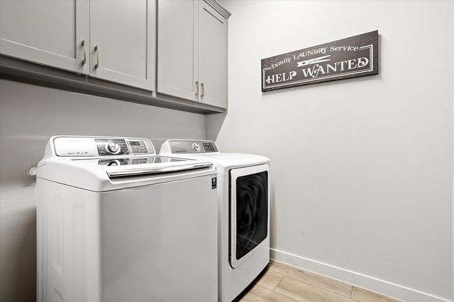 Washroom with light wood-style flooring, washing machine and clothes dryer, and cabinet space | Image 18