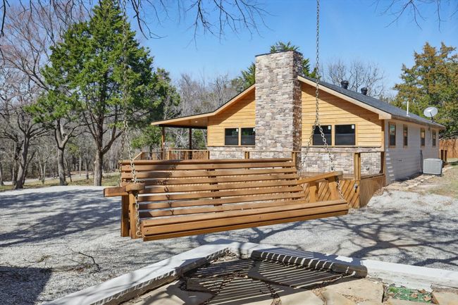 Back of house with stone siding, central AC unit, and a chimney | Image 32