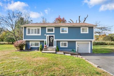 Bi-level home featuring a front yard and a garage | Image 1