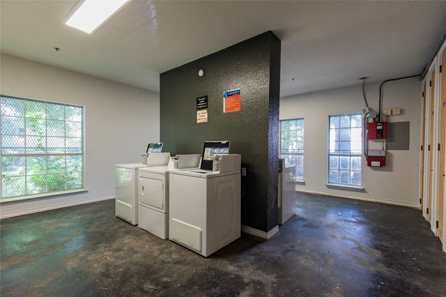 Shared laundry room featuring washer and dryer and electric panel | Image 13