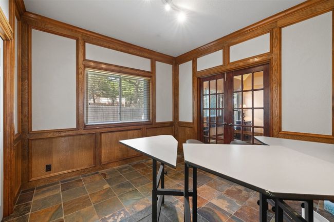 Dining space with french doors, stone tile floors, and a wainscoted wall | Image 23