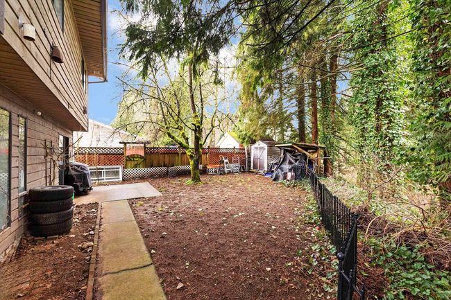 Fenced backyard with a storage unit and a patio area | Image 26