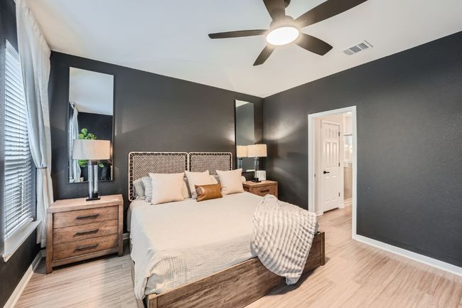 Bedroom with visible vents, baseboards, light wood-type flooring, and ceiling fan | Image 15