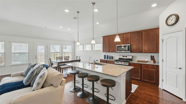 Kitchen with appliances with stainless steel finishes, vaulted ceiling, open floor plan, dark wood finished floors, and backsplash | Image 20
