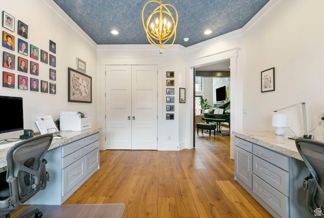 Office space featuring built in desk, an ornate ceiling, and light wood finished floors | Image 15