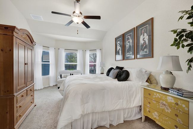 Bedroom featuring visible vents, a ceiling fan, light colored carpet, and lofted ceiling | Image 16