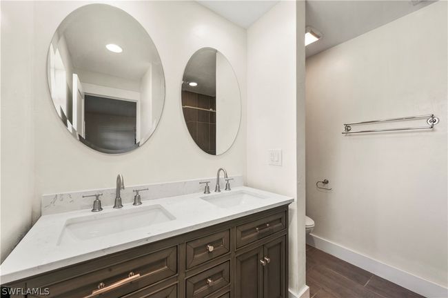 Bathroom with hardwood / wood-style flooring, double sink vanity, and toilet | Image 29