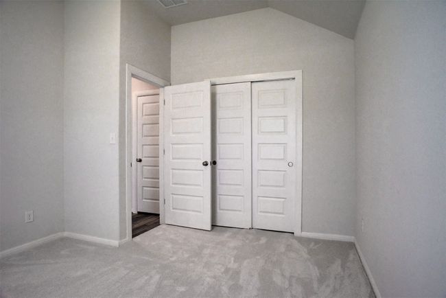 Unfurnished bedroom with vaulted ceiling, a closet, carpet flooring, and baseboards | Image 26