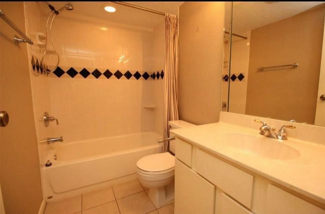 Full bathroom updated with cultured marble countertop, tile floors and designer insets in the tub/shower combo | Image 5
