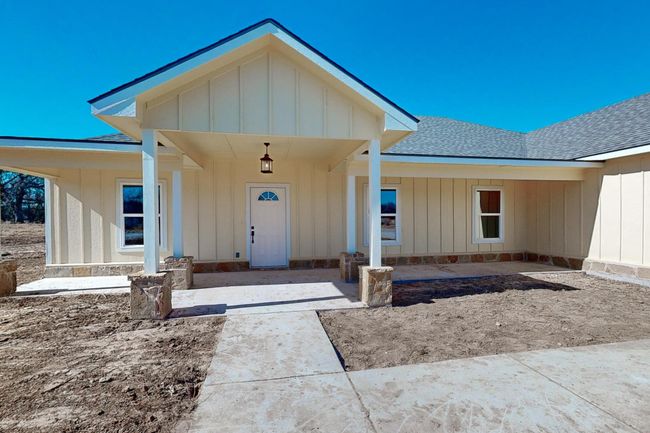 Doorway to property featuring roof with shingles and board and batten siding | Image 5
