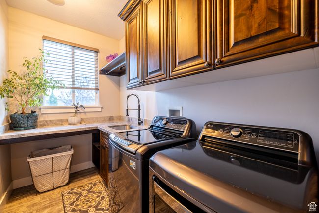 Laundry room with independent washer and dryer, cabinet space, and light wood-type flooring | Image 37