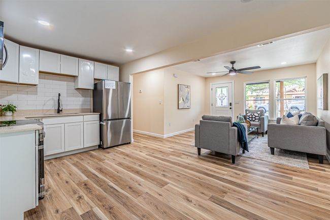 Kitchen featuring light countertops, a sink, freestanding refrigerator, light wood-type flooring, and open floor plan | Image 11