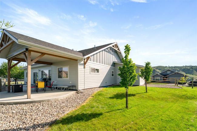 Back of property featuring board and batten siding, a patio, and a shingled roof | Image 28