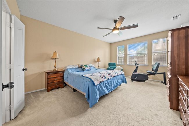 Bedroom featuring light colored carpet, baseboards, and a ceiling fan | Image 27