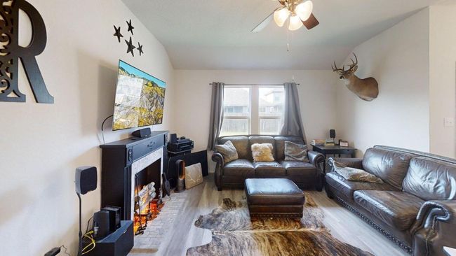 Living area featuring wood finished floors, lofted ceiling, and a ceiling fan | Image 21