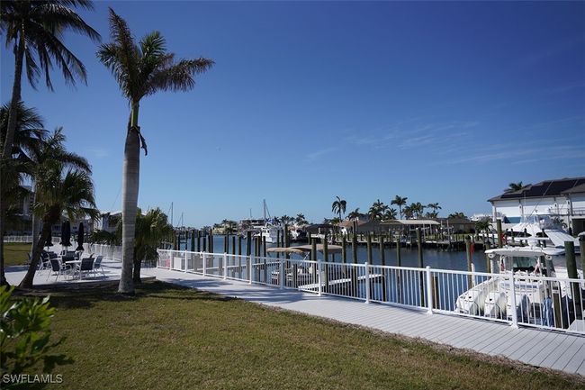 Boardwalk with fence and patio area featuring a water view | Image 9
