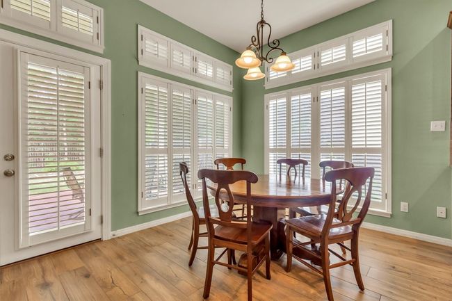 Dining space with baseboards, a notable chandelier, and light wood-style floors | Image 17