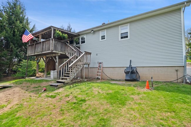 Rear view of property with a deck, stairway, and a yard | Image 34