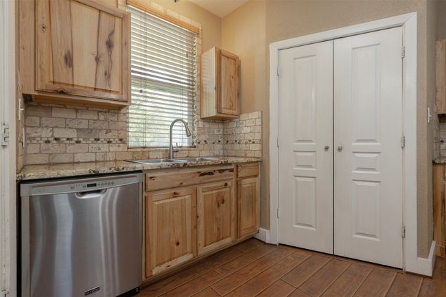 Kitchen with dishwasher, a sink, light brown cabinetry, and decorative backsplash | Image 9