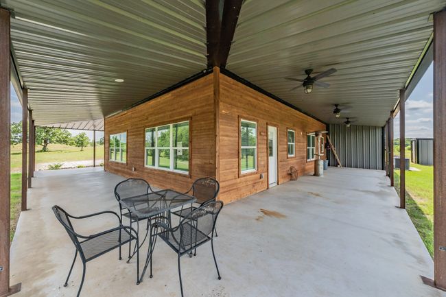 View of patio with a ceiling fan, central AC, and outdoor dining area | Image 6