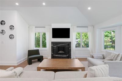 Living room featuring wood-type flooring, lofted ceiling, and a premium fireplace | Image 3