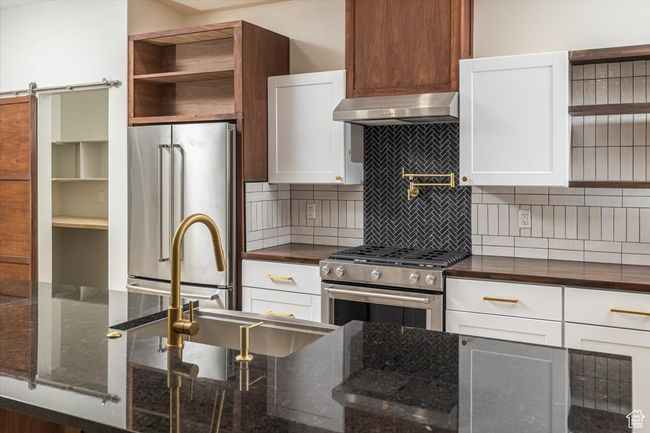 Kitchen featuring white cabinetry and high end appliances | Image 13