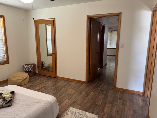 Unit B front bedroom with closet. view of hallway to bathroom and back bedroom. | Image 5