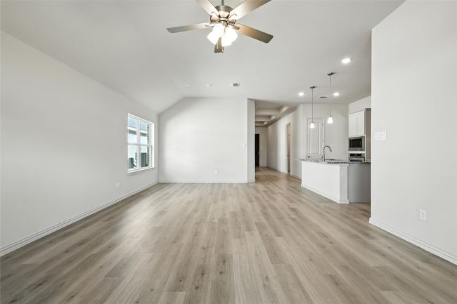 Unfurnished living room with recessed lighting, vaulted ceiling, light wood-style floors, and ceiling fan | Image 12
