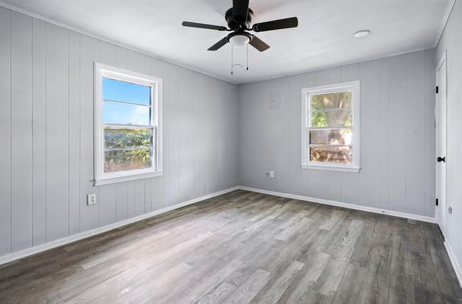 Unfurnished room featuring healthy amount of natural light, wood finished floors, and a ceiling fan | Image 12