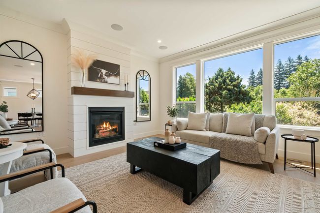 Living room with wood finished floors, a fireplace, ornamental molding, and recessed lighting | Image 11