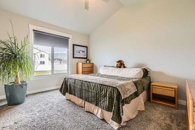 Bedroom featuring carpet floors, lofted ceiling, and ceiling fan | Image 12