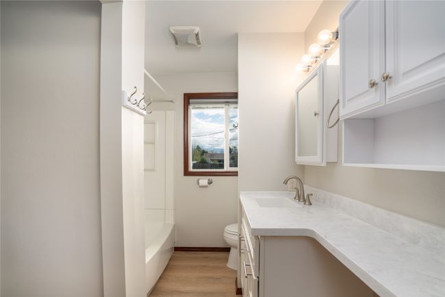 Bathroom featuring vanity, toilet, wood finished floors, shower / tub combination, and baseboards | Image 18