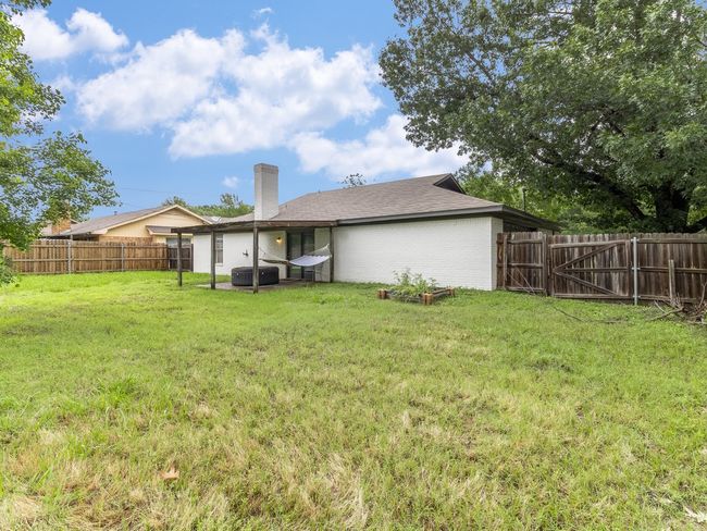 Rear view of house with a chimney, a fenced backyard, and brick siding | Image 25