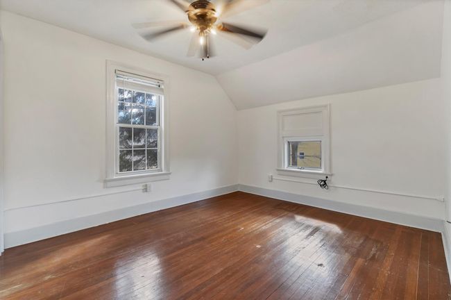 Additional living space with wood-type flooring, vaulted ceiling, a ceiling fan, and baseboards | Image 38