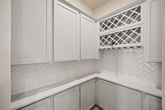 Right off the kitchen is the wine room with tile backsplash and plenty of storage space. This home is filled with many upgrades! | Image 13