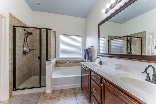 Full bathroom with a stall shower, tile patterned flooring, a bath, and double vanity | Image 13